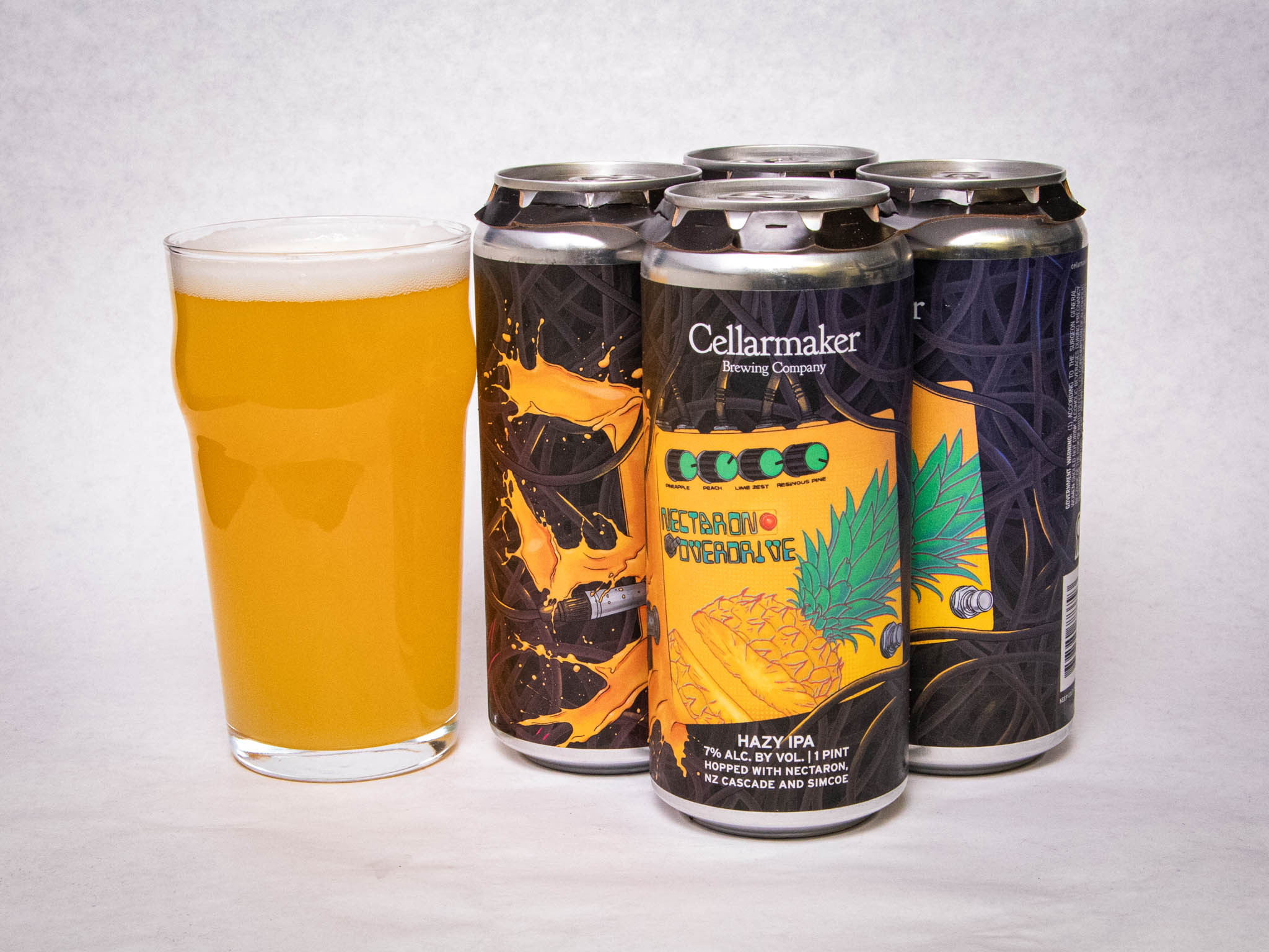 A Glass Of Hazy, Golden Beer Sits Next To Four Cans Labeled “Cellarmaker Brewing Company,” Featuring Colorful Artwork And The Name &Amp;Quot;Tetrahop Overdrive.&Amp;Quot; The Cans Display A Pineapple And Hop Design.