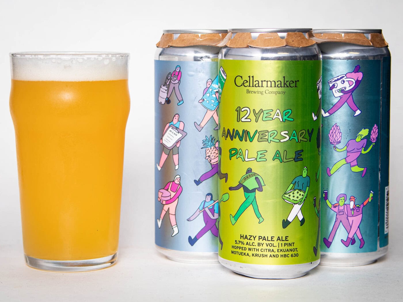 A Pint Glass Of Hazy Pale Ale Sits Next To Three Colorful Beer Cans. The Front Can Reads “Foreign Object - Wc Ipa - Tdne Collab,” Featuring Bright, Playful Illustrations Of People On All The Cans.